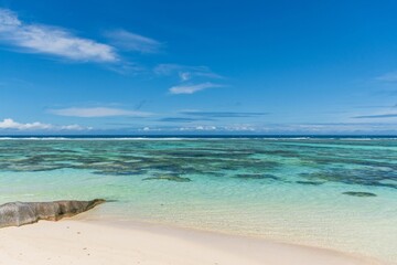 Landscape of the sea surrounded by a beautiful beach under a blue sky