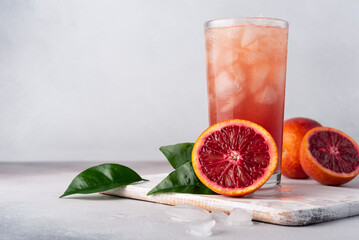 Juice or cocktail of red Sicilian oranges with ice cubes in a glass