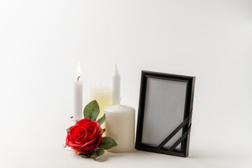 burning candle with other candles and red rose on white background steel flame fire