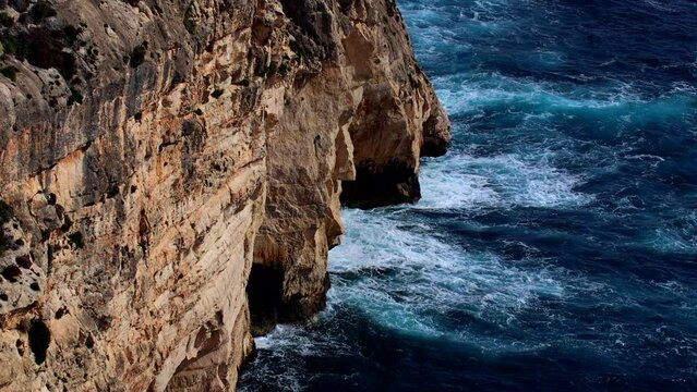 Aerial landscape over Breaking of Waves at rocky Cliffs in Gozo island in Malta