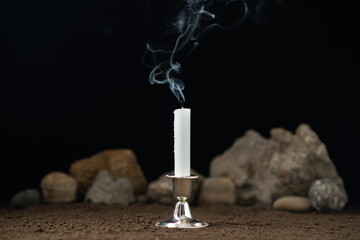 fireless candle with rocks around on a dark background death sci fi