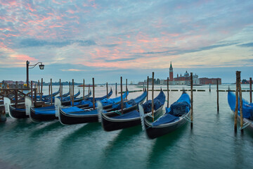 The most popular and romantic place in Venice. Gondolas moored at St. Mark's Square with the Church of San Giorgio di Maggiore in the background at sunset dawn, Venice. © Ryzhkov Oleksandr