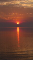 Fototapeta na wymiar Dramatic Orange Sunrise Over The Water