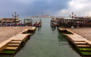 Fototapeta premium Traditional gondolas at the pier with the island of San Maggiore in the background.