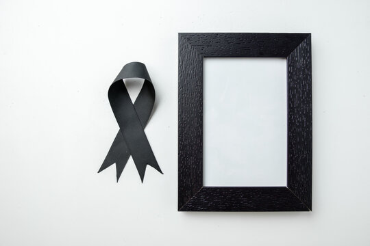 top view picture frame with black bow on white background funeral death