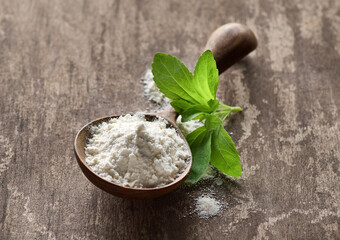 Stevia leaves with powder in wooden spoon