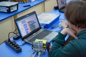 Children build and program construction robots at a robotics lesson at school. Education, children,...