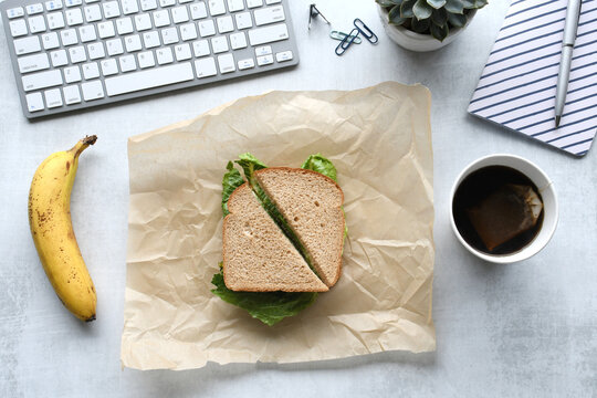 Sandwich banana at desk - working through lunch hour while eating at your workspace.