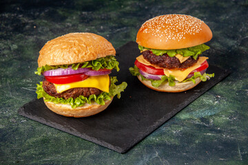 Above view of homemade delicious sandwiches on black board on gray blurred background