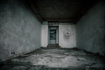 Gloomy interiors of an abandoned building. Empty room. Graffiti on the walls. Concrete room. Terrible abandoned hotel.