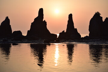 早朝の海岸に立つ奇岩