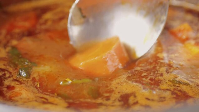 Hungarian goulash soup cooking close-up in pot, chef cook traditional polish or zech soup in restaurant. 