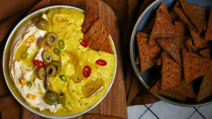 Dip hummus with olives and nachos chips