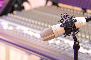 condenser microphone on audio mixing console background in recording studio