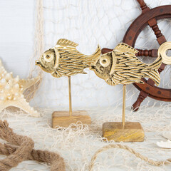 Zwei goldene Deko Fische mit Fischernetz, Seestern und Steuerrad als maritime Dekoration