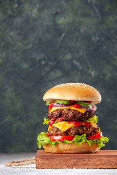 Front view of delicious homemade sandwich on wooden board on blurred background