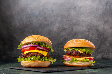Homemade delicious sandwiches on black board on dark gray blurred background