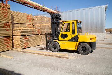 Sawing logs into boards.Timber products warehouse on a specialized site.