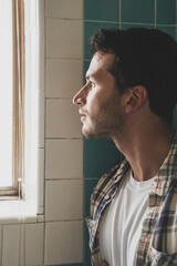 Fashionable bearded young man with tattoos in natural window light 