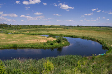 Summer landscape of a river floodplain with a winding channel.