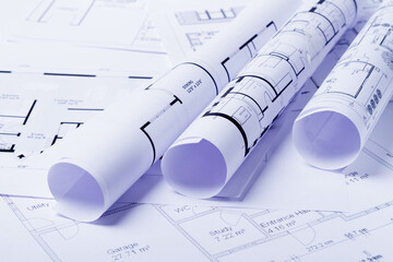 Construction plan. Scheme drawing rolled up in a roll. Home renovation planning.