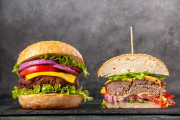 Top view of cut whole tasty sandwiches on black tray on dark mix color background
