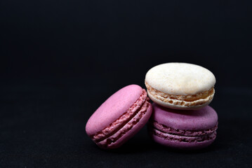 Multicolored cookies on a black background. Macaroni cookies close-up.Delicious and sweet cookies.