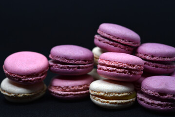 Multicolored cookies on a black background. Macaroni cookies close-up.Delicious and sweet cookies.