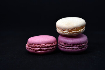 Multicolored cookies on a black background. Macaroni cookies close-up.Delicious and sweet cookies.