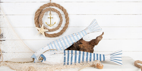 Mediterrane Dekoration aus Naturmaterialien für den Sommer aus Holz, Jute, Muscheln: Stranddeko mit Fische auf weißem Holz Hintergrund
