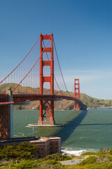 San Francisco Golden Gate Bridge as sen from the San Francisco City side. The sky is blue and the water green. Fort Mason is in the foreground.