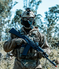 Anonymous soldier with AK-47 in the middle of the battlefield