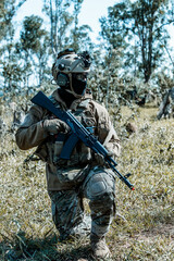 Anonymous soldier with AK-47 in the middle of the battlefield