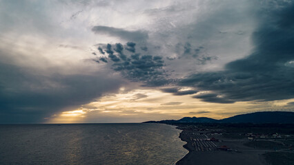 Fototapeta premium Aerial view of a sunset over the sandy beach ad sea coast