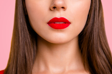 Fototapeta premium Close up half face crop portrait of brunette woman with red lips slightly opened her mouth isolated on vivid yellow background