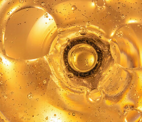 Macro image of yellow oil beginning to boil, bubbles rising to surface