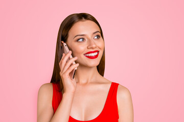 Close up portrait of charming and lovely girl with bright red lipstick on her lips talking on the phone on vacation isolated on yellow background