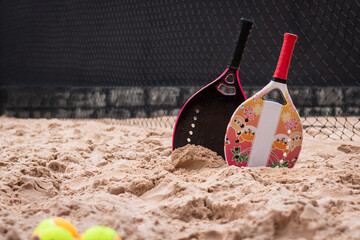 Women's and children's beach tennis rackets on the sand. Beach Tennis Kids. Family beach tennis. Mother and daughter at beach tennis. Copy space