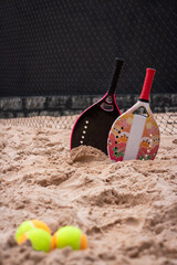 Women's and children's beach tennis rackets on the sand. Beach Tennis Kids. Family beach tennis. Mother and daughter at beach tennis. Copy space