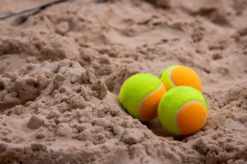 3 beach tennis balls in the sand. Copy space