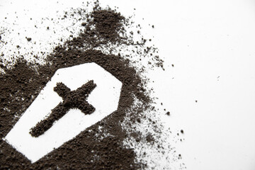 front view of coffin shape with dark soil and cross on white surface death funeral grim reaper