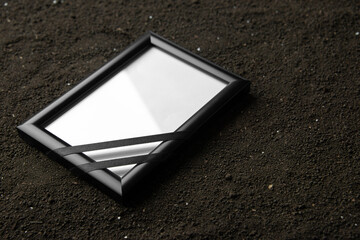 front view of picture frame on a dark soil grim reaper death photo funeral portrait