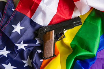 Pistol on rainbow and american flag. black weapon. Lgbt self defense concept.background