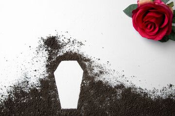 top view of coffin shape with dark soil on a white surface grim reaper funeral death