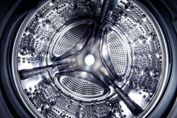 Inside of a shine steel drum of the washing or dryer machine. Laundry day. Daily household chores....