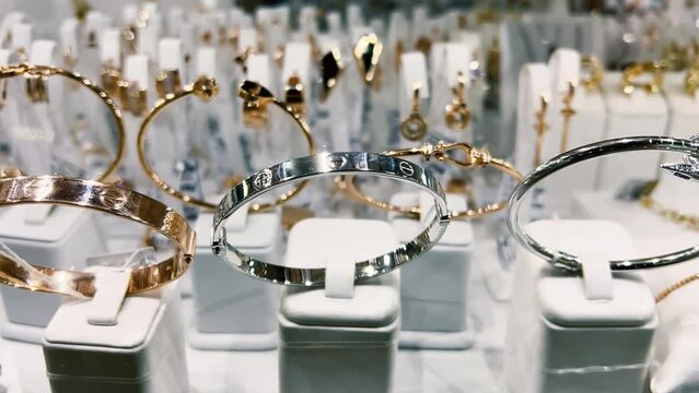 Women's gold and silver bracelets in a jewelry store window. Close-up