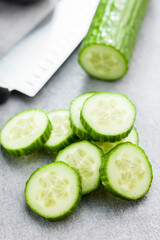 Sliced fresh green cucumber on kitchen table.