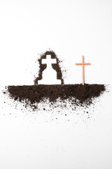 top view of cross shape with dark soil on white desk grim reaper death funeral
