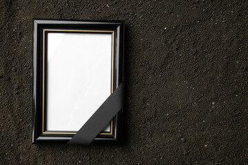 top view of picture frame on a dark soil grim reaper funeral death photo portrait