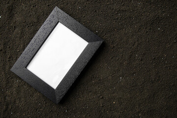 top view of picture frame on dark soil grim reaper funeral death